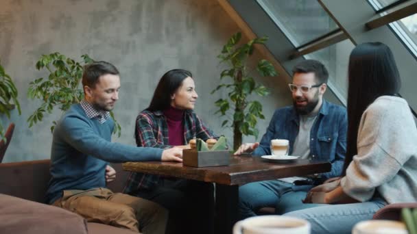 Gelukkige vrienden maken orde in cafe praten met vriendelijke lachende serveerster in schort binnen — Stockvideo