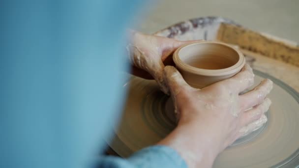 Close-up de mãos meninas fazendo pote na roda de cerâmica no estúdio ocupado com atividade criativa — Vídeo de Stock