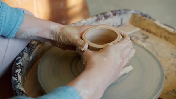 Creative lady potter making bowl on throwing wheel shaping clay into ceramic artwork — Stock Video