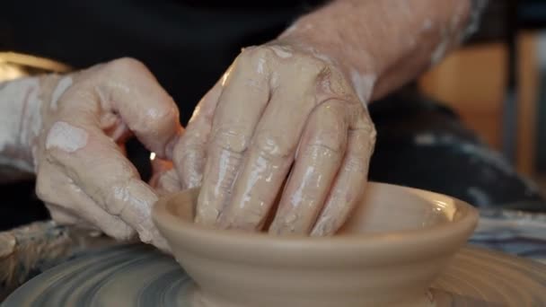 Close-up of adult mans hands shaping clay into beautiful hand-made bowl on throwing-wheel — Stock Video