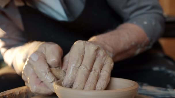 Крупный план старых мастеров, делающих красивые чаши на вращающемся колесе в мастерской — стоковое видео