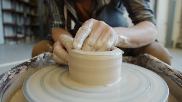 Gros plan des mains de mans concevant et fabriquant un bol en argile dans un atelier de poterie — Video