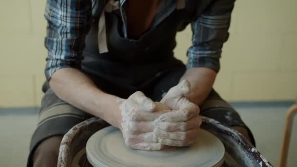 Hábil jovem oleiro moldando vaso de cerâmica de barro em transformar a roda de arremesso em estúdio — Vídeo de Stock
