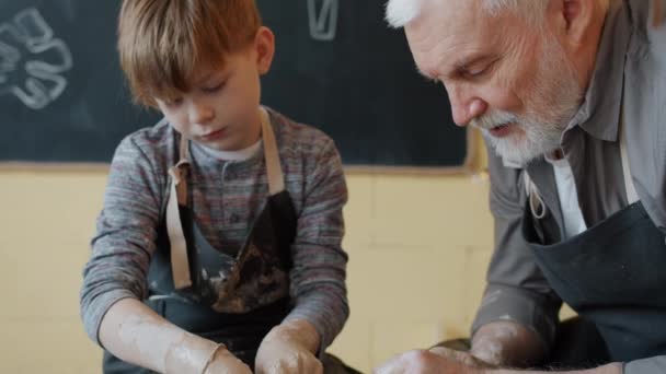 Professionell keramik lära liten elev att arbeta med kast-hjul under keramik klass — Stockvideo