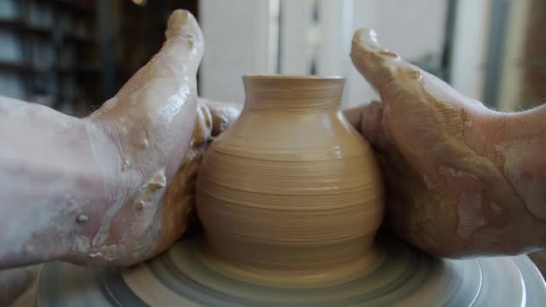 Cinemagraph loop de pote de cerâmica girando na roda oleiros em mãos sujas de artesão — Vídeo de Stock