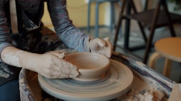 Slow motion close-up of childs dirty hands shaping bowl from clay on pottery wheel — Stock Video