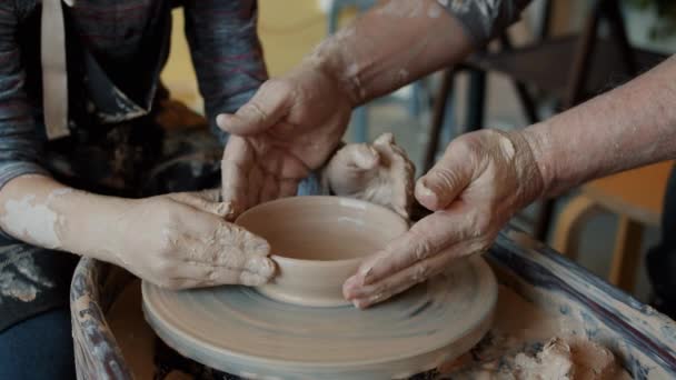 Close-up of hands man and boy shaping bowl on pottery wheel molding wet clay — Stock Video