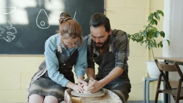 Rozkošný mladý pár pracující s hlínou na keramice kolo mluvit a smát — Stock video
