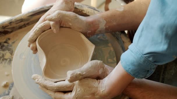 Close-up of man and womans hands making ceramic bowl in shape of heart in workshop — Stock Video