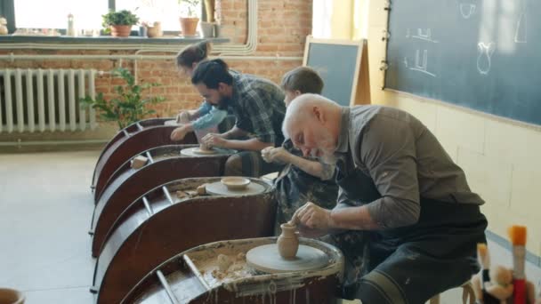 Zpomalení pohybu dospělých a dítěte pracující s keramickými koly výrobu keramiky v dílně — Stock video