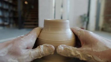 Seramik kâse çömlekçi çarkında dönerken usta killeri şekillendiriyor.