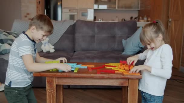 Dzieci brat i siostra bawią się zabawkami, podczas gdy nieostrożna niania rozmawia przez telefon komórkowy w domu — Wideo stockowe