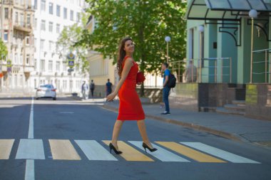 Kırmızılı kadın. Elbise genç güzel esmer kadın sokak yaya geçidi üzerinde haçlar.