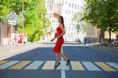 Kırmızılı kadın. Elbise genç güzel esmer kadın sokak yaya geçidi üzerinde haçlar.