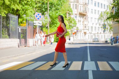 Kırmızılı kadın. Elbise genç güzel esmer kadın sokak yaya geçidi üzerinde haçlar.