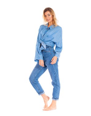 Tam uzunlukta portresi beyaz bir arka plan üzerinde izole gülümseyen sevimli genç bir sarışın kadın ayakta kot