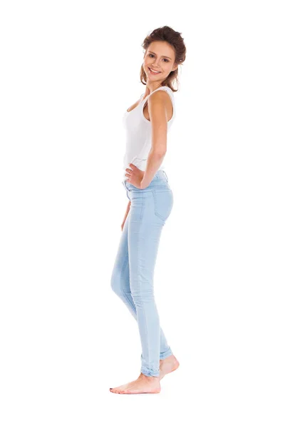 Mujer joven en pantalones vaqueros azules de pie aislado en un fondo blanco — Foto de Stock
