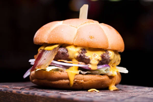 Burger with melted cheese for football fans. Big cheeseburger with melted cheese