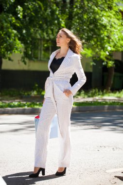 Tam büyüme beyaz takım elbise ve mavi çanta, sokak yaz açık havada güzel bir genç esmer kadının portresi