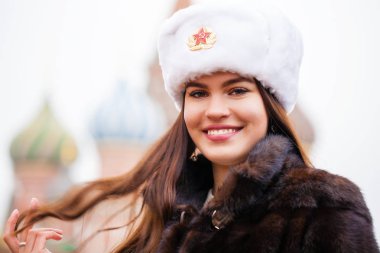 Rus güzellik. Bir kürk şapka kırmızı bir kare Moskova'da karşı beyaz şapkalı güzel bir genç kız portresi