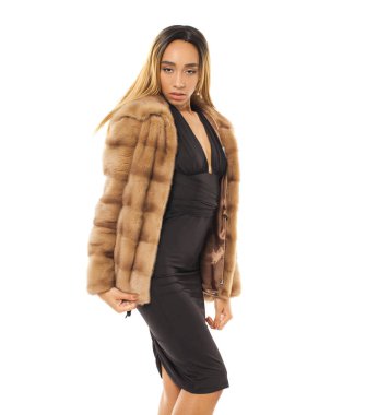 Bej kürk manto ve elbise şehvetli genç Afrikalı kadın portresi kapatın. Kadın beyaz arka plan stüdyo çekim.