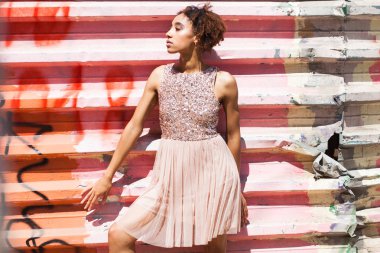 Sokak moda modeli. Pembe elbiseli bir Afrika genç kadın portresi