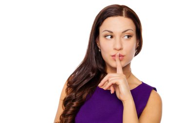 Kadın sessizlik gerektiriyor. Genç güzel esmer kız işaret parmağı dudaklar için sessizlik, beyaz arka plan üzerinde izole işareti olarak koymak