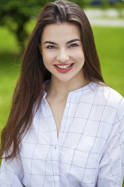 Taze ve temiz tenli, güzel, genç, mutlu esmer bir kadının açık hava yaz portresi.