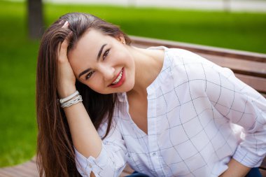 Taze ve temiz tenli, güzel, genç, mutlu esmer bir kadının açık hava yaz portresi.