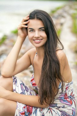 Genç ve güzel bir kadının portresi. Yeşil arka planda yaz mevsimi.