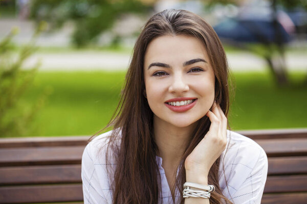 Closeup portrait of a happy young woman smiling, summer street outdoors