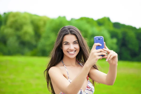 夏の公園での携帯電話で撮影した美しい少女 — ストック写真