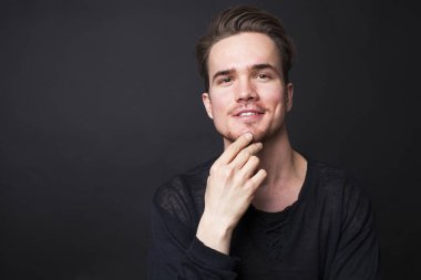 Karanlık bir arka plan üzerinde genç bir adam portresi stüdyo