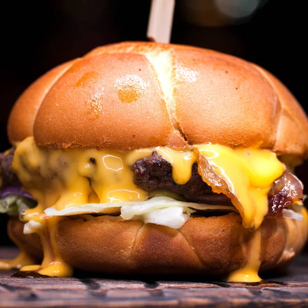 Burger with melted cheese for football fans. Big cheeseburger with melted cheese