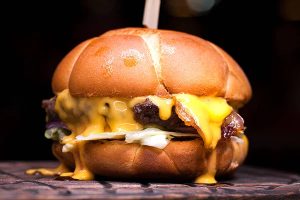 Burger with melted cheese for football fans. Big cheeseburger with melted cheese