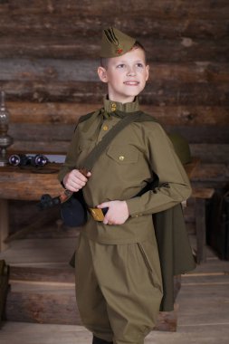 Rus çocuk bir sığınağın çubuklarından arka plan üzerinde bir dürbün ile eski Sovyet askeri üniforması giyen