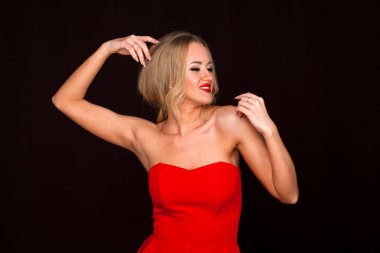 Güzel genç yetişkin çekici seksi ve duygusallık sarışın içinde kadın koyu arka plan üzerinde izole kırmızı elegance moda portre