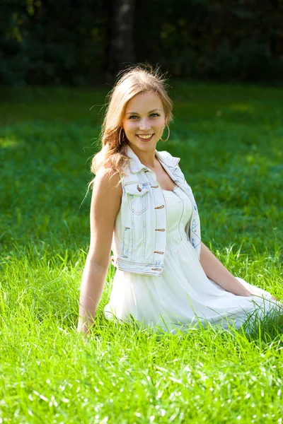 Jovem Mulher Loira Bonita Vestido Branco Sentado Grama Verde Parque — Fotografia de Stock