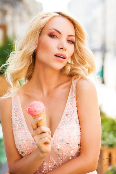 美丽性感的年轻金发女郎的肖像 长卷曲的头发吃美味的冰淇淋 — 图库照片