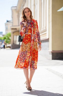 Portre tam uzunlukta içinde kırmızı çiçekler, yaz sokak açık havada Genç güzel esmer kadın