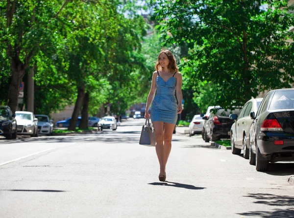 丰满的画像 年轻美丽的黑发女子穿着蓝色短裙走在大街上 夏日露宿街头 — 图库照片