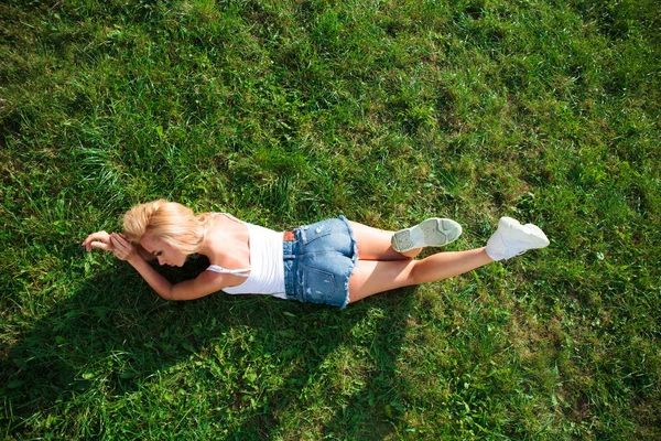セクシーな金髪美人は青いデニムのショート パンツに身を包んだ ジーンズ服のファッションモデル 夏公園屋外 — ストック写真