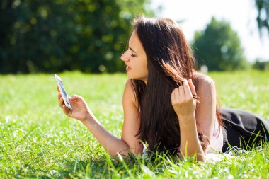Mutlu güzel esmer kız bir yaz parkta telefonla arama