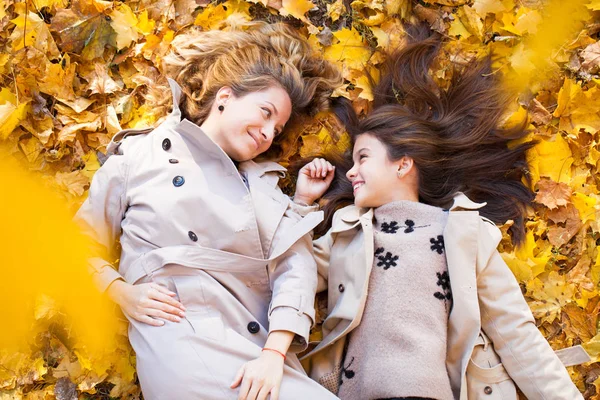 若い母と娘が秋の公園で歩いています — ストック写真