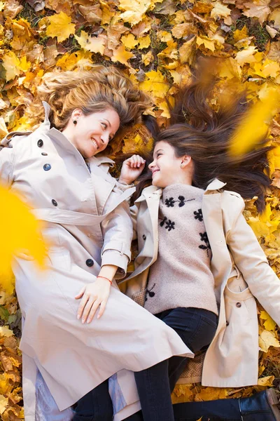 若い母と娘が秋の公園で歩いています — ストック写真