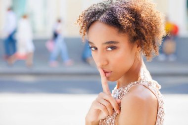 Bir güzel karışık yarış Afro-Amerikan kız ya da sessizlik için sorarak veya gizli tutmak onun dudakları parmağına ile giyen genç kadın