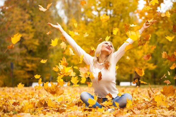 秋天公园里穿着蓝色牛仔裤的金发女郎 — 图库照片