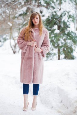 Tam uzunlukta kürk giyen genç güzel zarif esmer kadın portresi. Moda kız kış street yürüyüş.