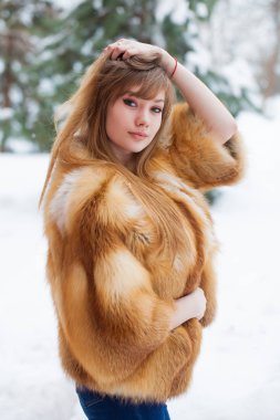Tam uzunlukta kürk giyen genç güzel zarif esmer kadın portresi. Moda kız kış street yürüyüş.