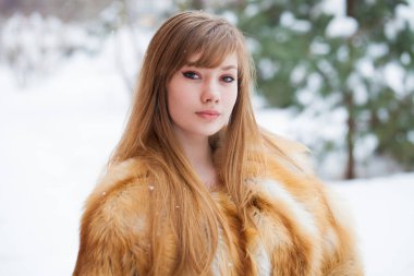 Tam uzunlukta kürk giyen genç güzel zarif esmer kadın portresi. Moda kız kış street yürüyüş.